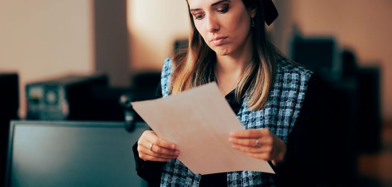 Mujer revisando contrato bancario con cláusulas absivas